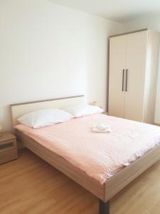 a bedroom with a large bed with a cabinet at Apartmani "Bodulo" in Povljana