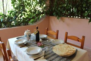 una mesa con platos y una botella de vino. en Agriturismo Muristene en Dorgali