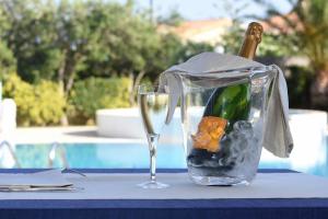 eine Flasche Champagner und ein Glas Wein auf dem Tisch in der Unterkunft Hotel Ristorante Il Vascello in Costa Rei