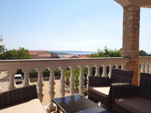 d'un balcon avec des chaises et une table offrant une vue sur l'océan. dans l'établissement Apartmani "Bodulo", à Povljana
