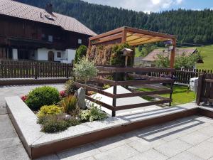 una valla de madera y un jardín con flores y plantas en Haus Martina Buchhammer, en Fendels