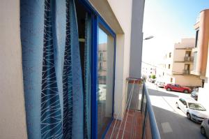タリファにあるLivingtarifa Lances Blueの建物内のバルコニー(青いガラスのドア付)