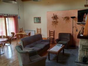 a living room with a couch and chairs and a table at Hostal Pas De La Pera in Aransá