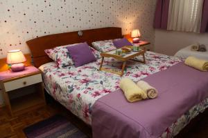 a bedroom with a bed with a table on it at Apartman Lana in Biograd na Moru