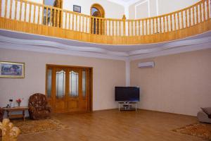 uma sala de estar com uma escada e uma televisão de ecrã plano em Villa on Fetali Khan em Quba