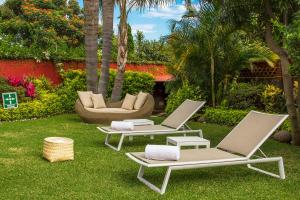 two lounge chairs and a couch in a yard at Quinta Elvira in Cuernavaca