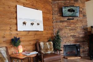 a living room with a fireplace and a picture of animals at Elkhorn Cabins and Inn in West Yellowstone