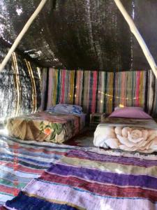 una stanza con due letti e un tappeto di Amoudou Lodge Camp a Tissint
