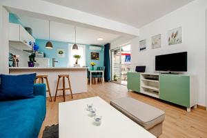 a living room with a blue couch and a kitchen at Little house - just few steps from the city center in Rovinj