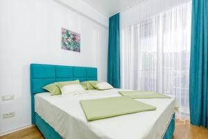 a bedroom with a blue and white bed and a window at Lux Apartments Harmonia in Budva