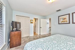 a bedroom with a bed and a flat screen tv at Le Monaco Condo at Olde Naples in Naples