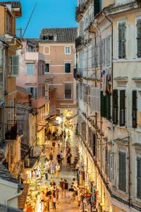 een menigte mensen die door een straat lopen tussen gebouwen bij Coconella Suite in Corfu-stad