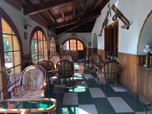 una habitación con un montón de sillas y ventanas en Hostal de la Gloria en Viladrau