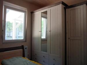 a bedroom with a dresser and a window at Strandhaus Vielmeer - exklusiv mit Sauna & Kamin direkt am Strand in Dranske