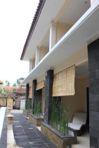a porch of a house with a bench and plants at Radha Bali Hotel in Kuta