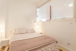 バレンシアにあるEl Rincón de Tintín - Ruzafa - Wifi 5Gの白いベッドルーム(ベッド1台、窓付)