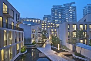 深セン市にあるCM Serviced Apartment Shenzhen Hillsideのプール付きのアパートメントビルの建築様式