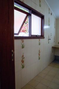 a bathroom with a window and a tiled wall at Piano B&B + Coworking in Porto Alegre