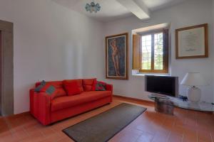 ポンタッシエーヴェにあるVilla La Tinaiaのリビングルーム(赤いソファ、テレビ付)