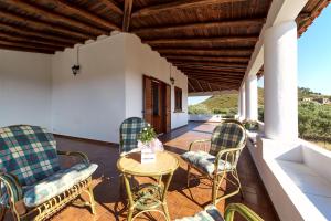 um pátio com cadeiras e uma mesa num alpendre em Capo Grillo Cottage Villa em Vulcano