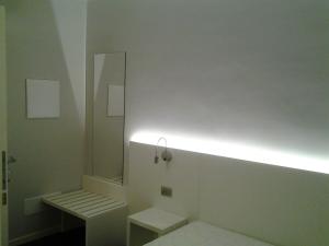 a bathroom with a toilet with a light on the wall at Albergo Dongo in Dongo +89 photos