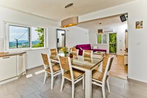 a kitchen and dining room with a table and chairs at Forest House Silva in Hrvace