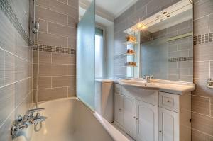 a bathroom with a tub and a sink and a mirror at Residence Chryseis in Cannes