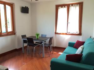 - un salon avec une table et un canapé vert dans l'établissement Casa Lorenzo, à Bellagio