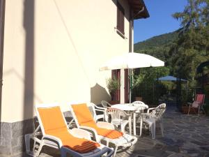 a group of chairs and a table with an umbrella at Casa Lorenzo in Bellagio