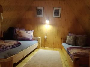 CicheにあるAgroturystyka u Jagodow Domek Goralskiの木製の壁にベッド2台が備わる部屋