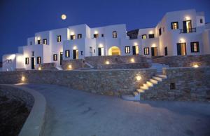 a large white building with a stone wall at night at Belvedere Apartments in Chora Folegandros