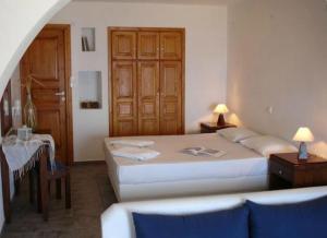 a bedroom with two beds and a table and a door at Belvedere Apartments in Chora Folegandros