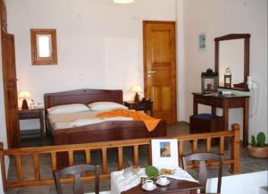 a bedroom with a bed and a table and chairs at Belvedere Apartments in Chora Folegandros