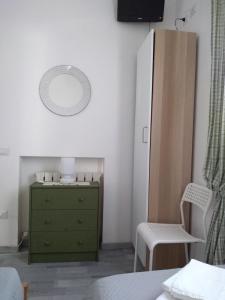 um quarto com uma cómoda verde e um espelho em B&B Gli Alberetti em Loreto