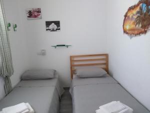 2 camas individuais num quarto com paredes brancas em B&B Gli Alberetti em Loreto