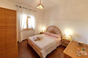 a bedroom with a bed with pink pillows on it at Capo Grillo Cottage Villa in Vulcano