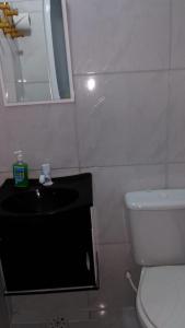 uma casa de banho com um WC, um lavatório e um espelho. em Pousada Brenda em Fortaleza