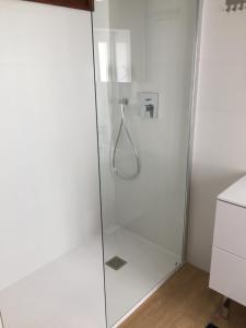 デニアにあるАпартаментыのバスルーム(ガラスドア付きのシャワー付)