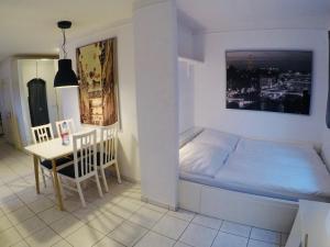 a small bedroom with a bed and a table at Exkl. Studio nähe Messe in Nuremberg