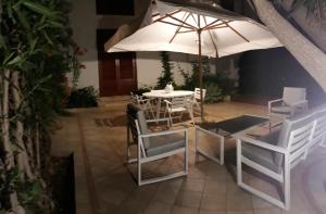 a table and chairs with an umbrella in a courtyard at Casa Giummarra in San Vito lo Capo