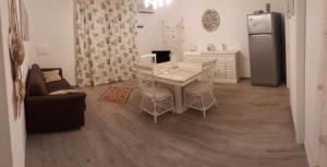 een keuken met een tafel en stoelen en een koelkast bij Casa Giummarra in San Vito lo Capo