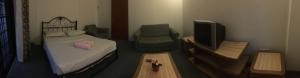 Habitación con cama, TV y mesa. en 2 bedroom Paul Kempas D2-904 GVR apartment en Genting Highlands