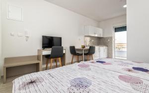 a bedroom with a bed and a desk and a kitchen at Villa Lajna in Neum