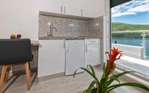 a kitchen with white cabinets and a view of the water at Villa Lajna in Neum