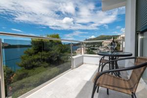 a balcony with a table and chairs and a view of the water at Villa Lajna in Neum