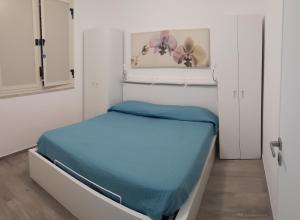 a small bedroom with a bed with blue sheets at Casa Giummarra in San Vito lo Capo
