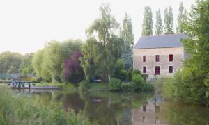 Évran的住宿－Le Moulin du Mottay，建筑物旁河边的建筑物