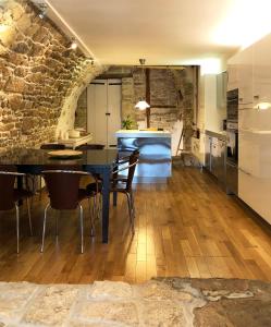 cocina y comedor con mesa y sillas en Villa Authentique et Architecturale - Centre Ville, en Forcalquier