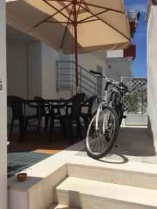 - un vélo garé sur une terrasse avec un parasol dans l'établissement Charm Holiday, à Terrasini