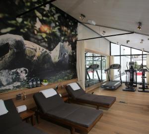 a gym with two chairs and a large painting on the wall at Hotel München Palace in Munich